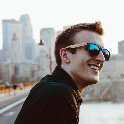 man in sunglassess smiling after successful hair restoration treatment