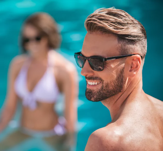 A guy with good hair, wearing sunglasses at the pool