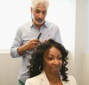 HairClub - Hair Solutions Experts - a HairClub Hair Loss Specialist is examining a client's hair at a HairClub Center.